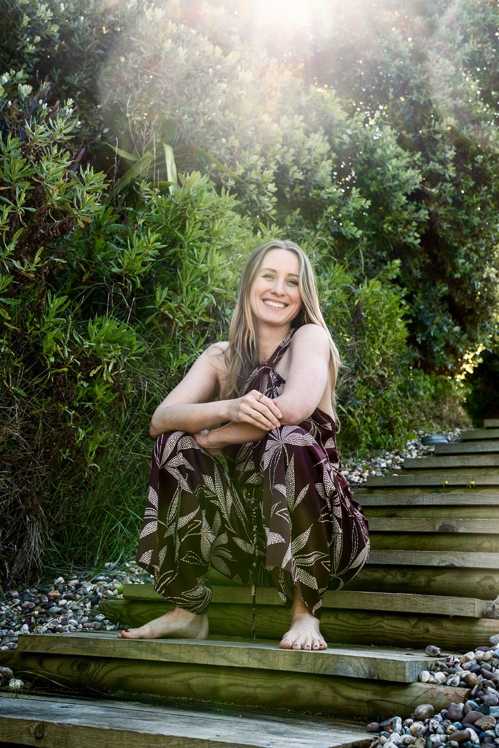 Isabel Maria sitting on garden steps in Portugal, surrounded by lush greenery